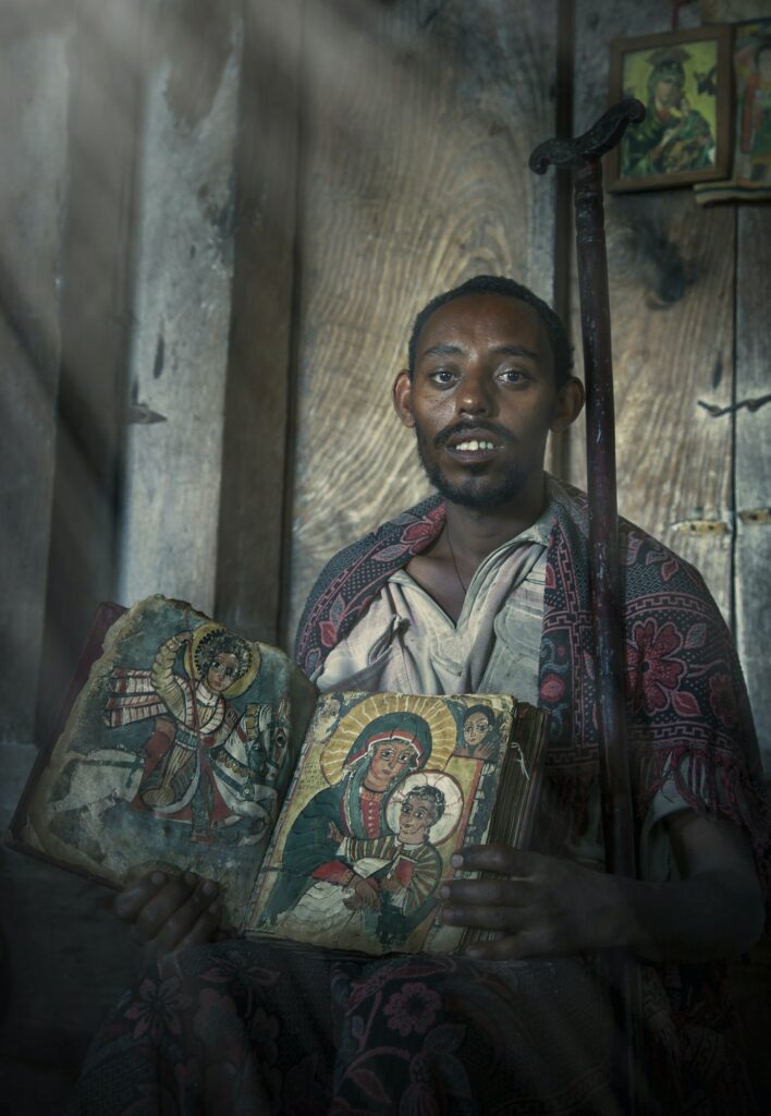 Portrait of priest with an old religious book in Ashen Maria Monastery, Lalibela, Ethiopia, Africa
